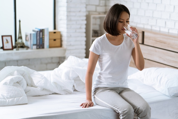 Asian women drink water after waking up in the morning.