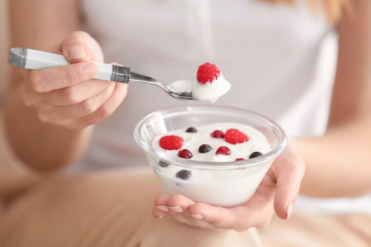 Young woman eating yogurt, closeup