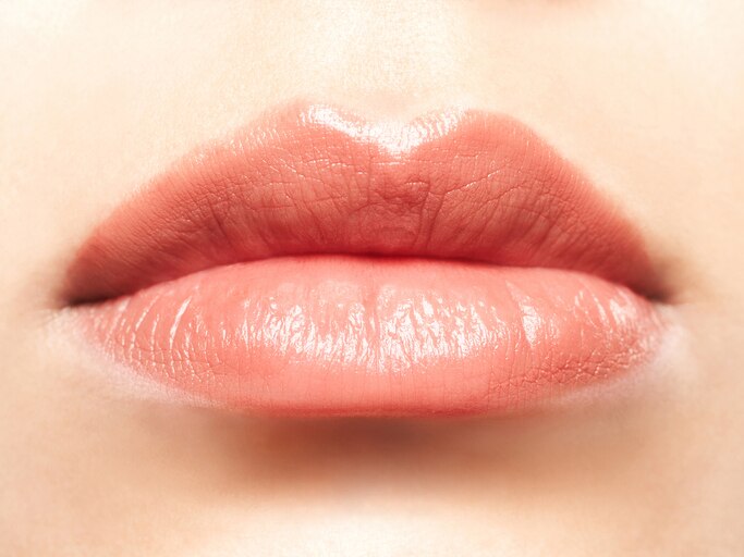 Close-up of a woman's plump pink lips. Horizontal shot.