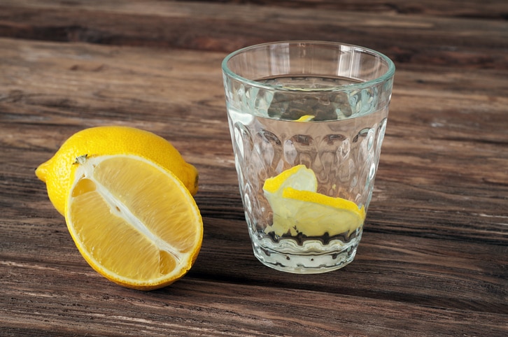 glass of water with lemon slices on a wooden background. Copy space. Free space for text