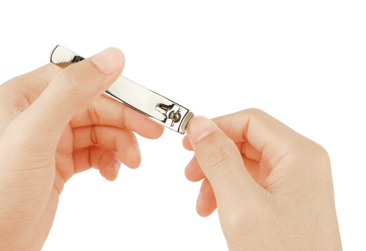 human use cutter nail cut his nail on white background with clipping path