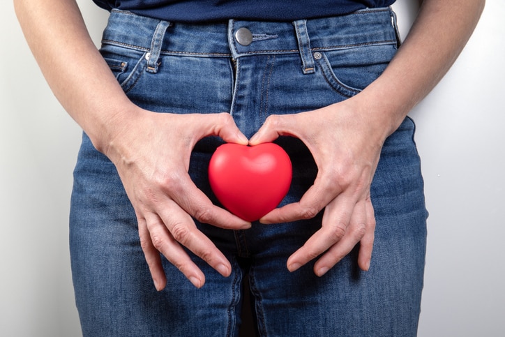 Reproductive health, menopause, hygiene and vaginal candidiasis concept. Red rubber heart in woman's hand