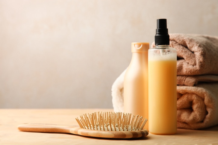 Hair care products on wooden table on neutral background. Copy space.