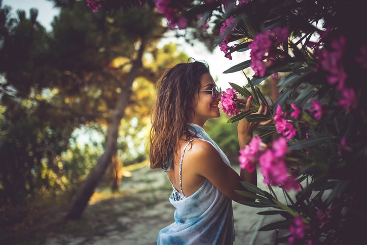 Woman smelling tropical pink flowers