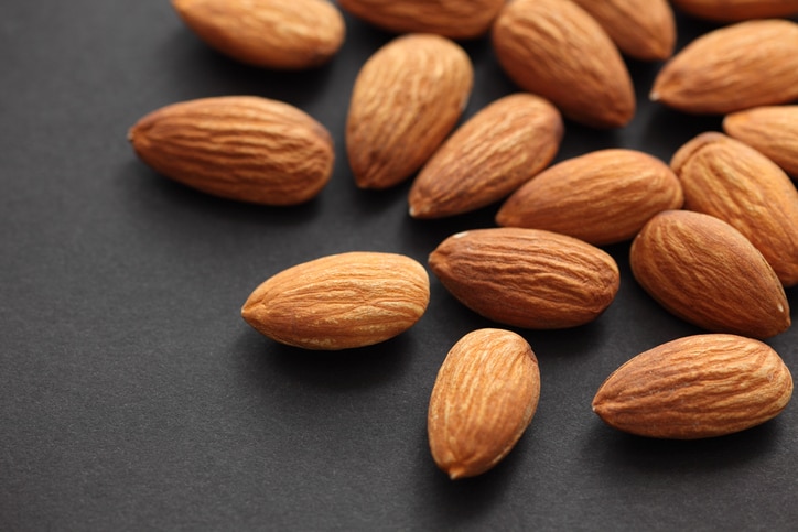 Almonds on black paper background. Close-up.