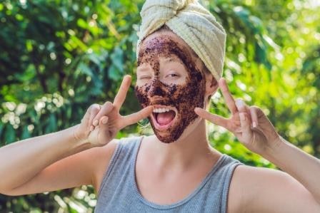 Face Skin Scrub. Portrait Of Sexy Smiling Female Model Applying Natural Coffee Mask, Face Scrub On Facial Skin. Closeup Of Beautiful Happy Woman With Face Covered With Beauty Product. High Resolution. (Face Skin Scrub. Portrait Of Sexy Smiling Female