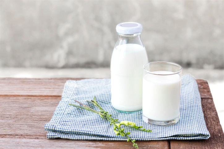 glass of milk and bottle of milk on the wood table. with copy space for text.