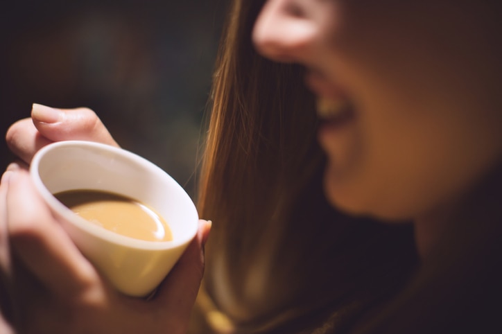 Girl holding cup of coffee close up