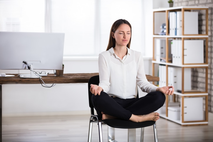 Young Businesswoman Sitting On Chair Doing Meditation