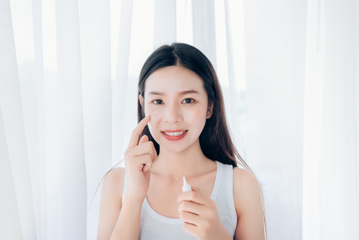 Beauty Asian woman use acne gel skincare after cleansing on face his happiness.