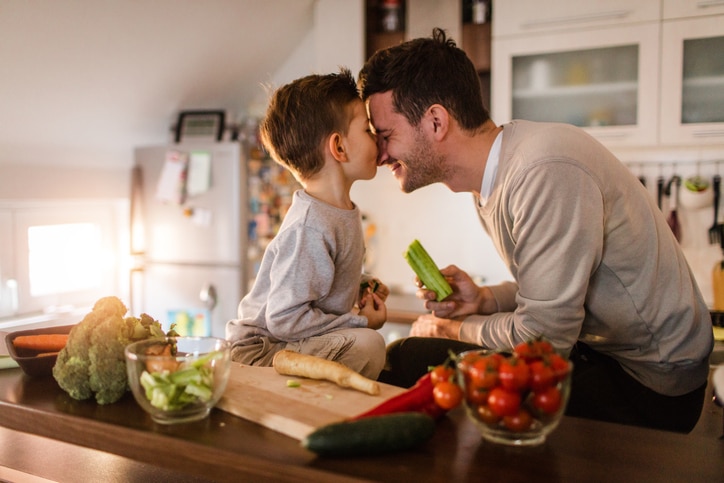 Father and son having fun in the kitchen while preparing healthy food