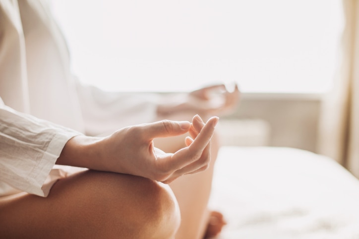 Hands of young beautiful woman practicing yoga indoors