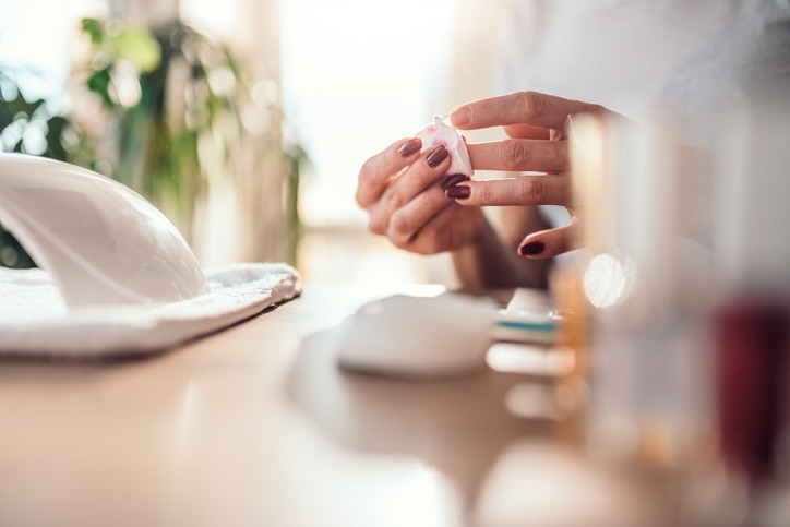 Woman removing nail polish with cotton pads