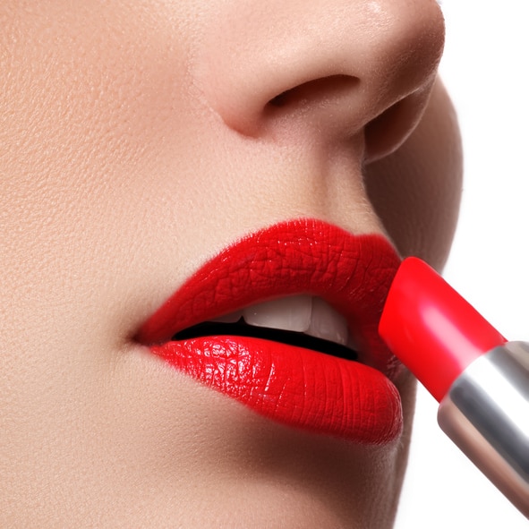 Woman applying lipstick. Model painted red lips. Beauty face with perfect fresh skin. Beauty concept