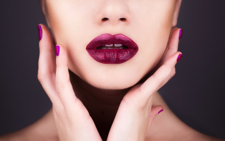 beutiful female face with hands and purple lips