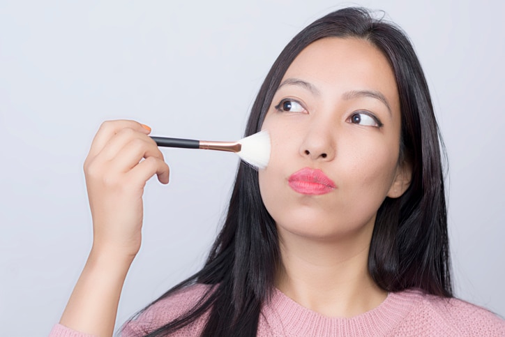 Girl with makeup brushes