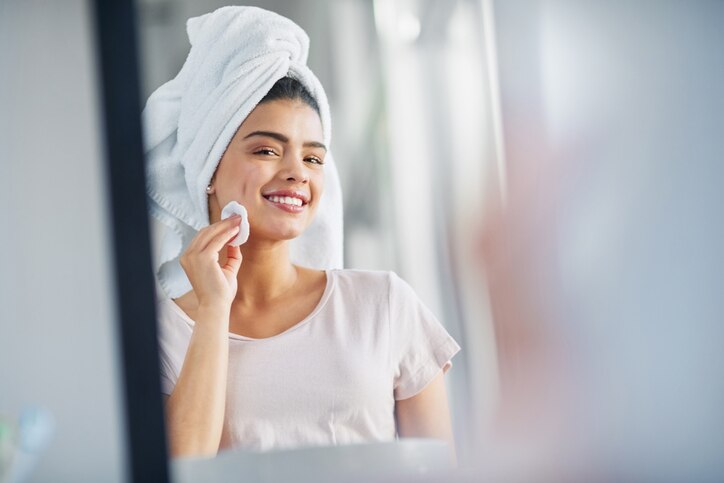 Shot of a beautiful young woman cleaning her face with cotton wool in the bathroom at home