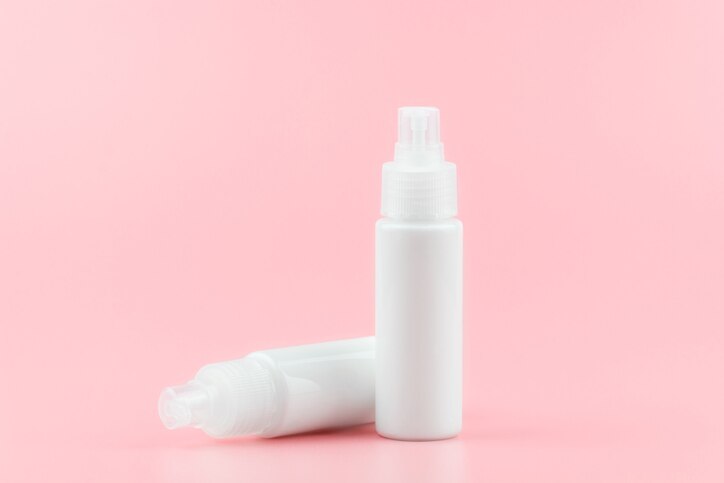 White cosmetic plastic bottle with pump packaging for cream, lotion, medicine, shampoo or liquid soap isolated on pastel pink background. Blank skincare beauty product template.