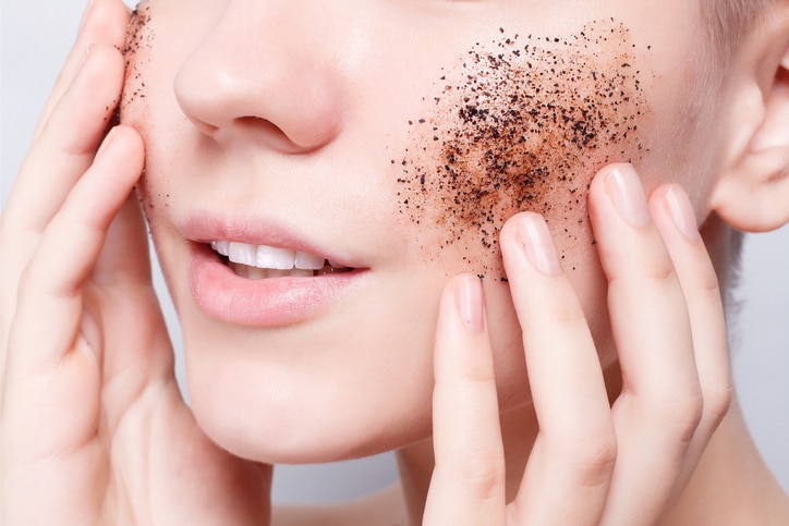 health, people, Skin Care, youth and beauty concept - Smiling woman with short hair, bald cleans the skin coffee skrub, studio shot, close-up portrait. Clean Fresh Skin close up. Spa Woman Smiling