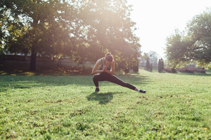 Young woman doing some warm-up exercises before running.