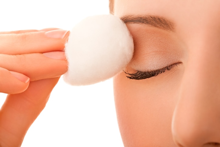 Female using cotton ball to remove eye make-up