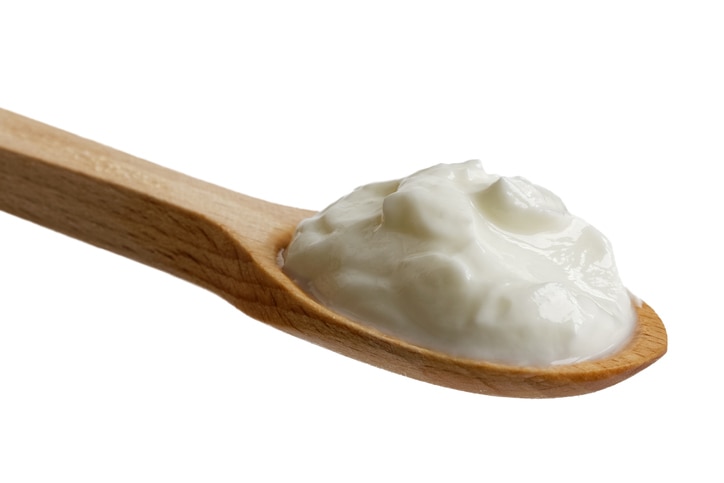 Skyr yoghurt on wooden spoon isolated on white.