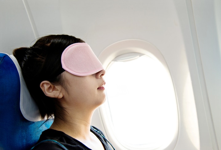 Young woman having nap in a plane.