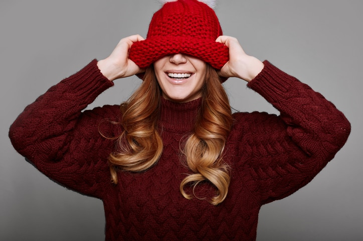 Portrait of beautiful redhead woman in red sweater and hat