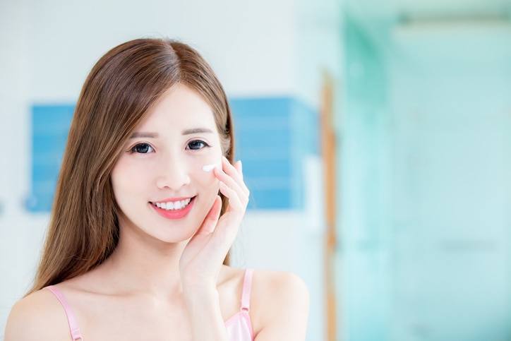 Beauty skin care woman apply cream on her face