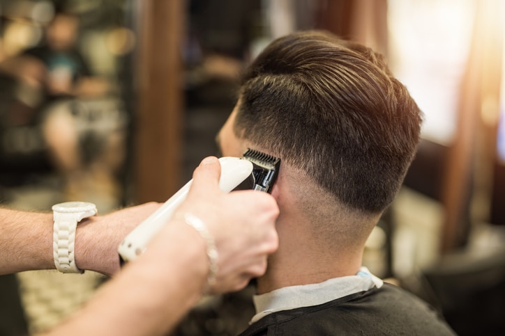 Young man getting a modern haircut. Rear view.