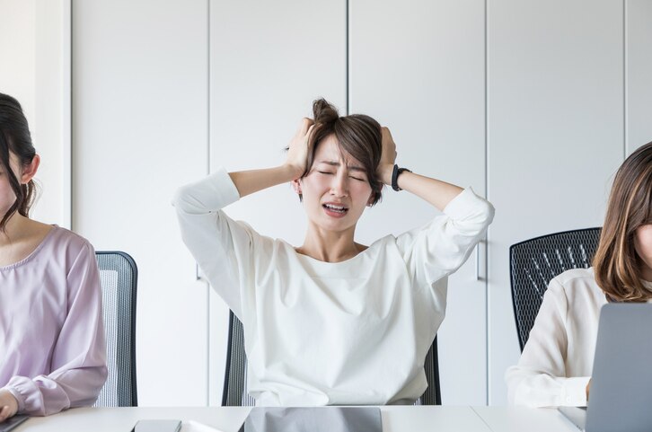 Young woman holding her head.