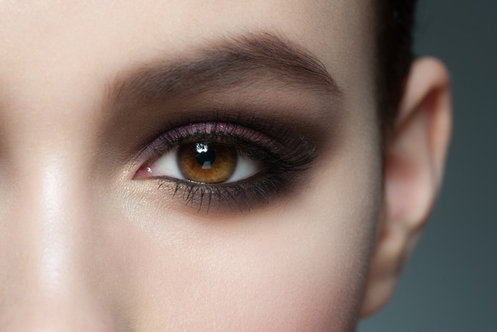 Closeup of beautiful woman eye with bright stylish makeup with long lashes