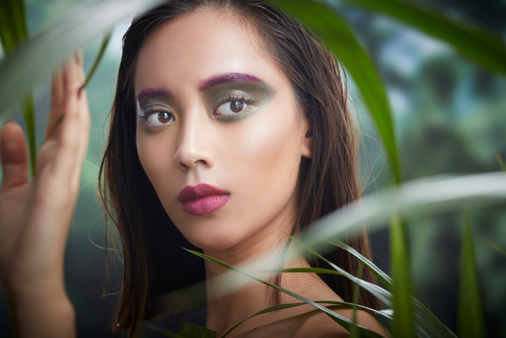 asian woman with colorful make up in a forest portrait