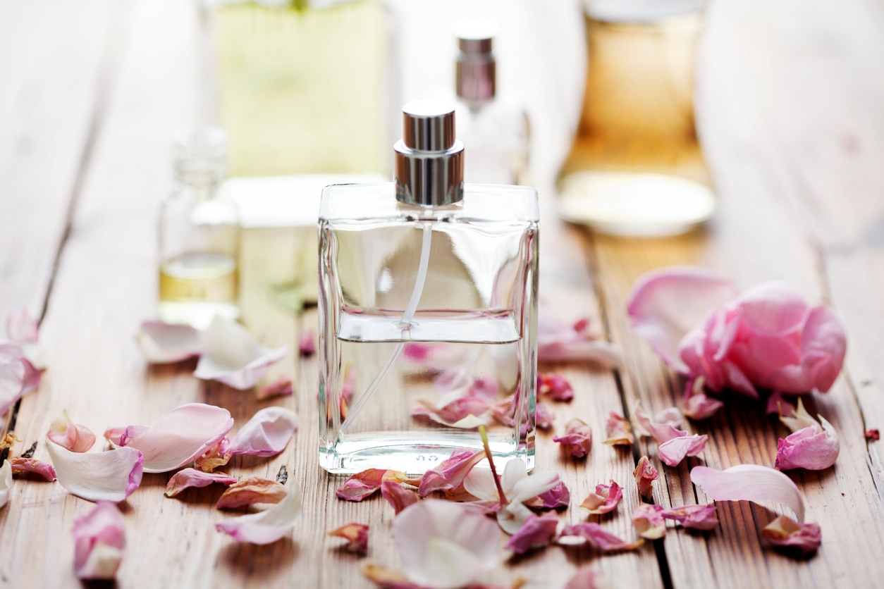 selection of perfume bottles surrounded by flower petals